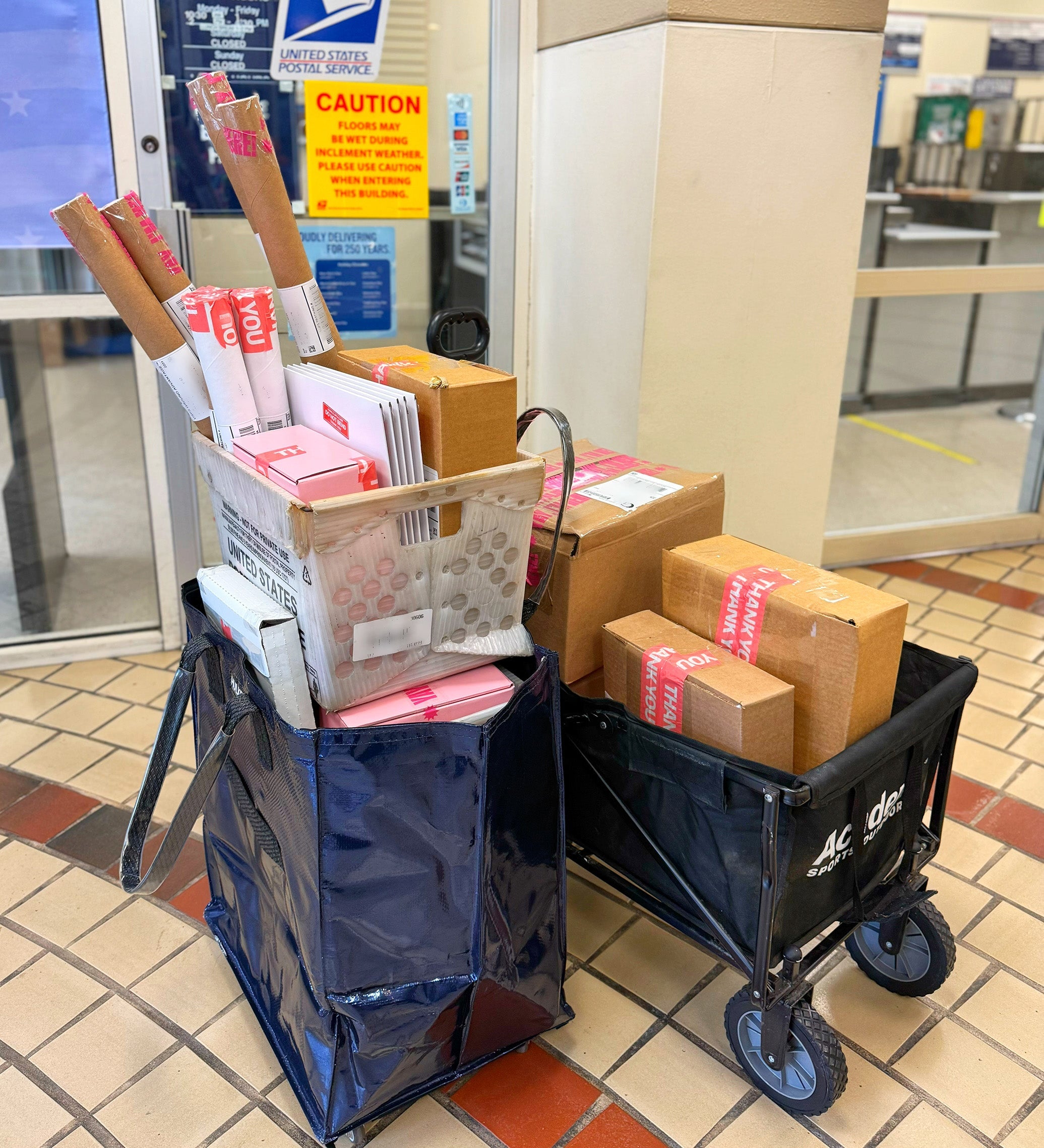 Packages in wheeled carts heading to the post office.