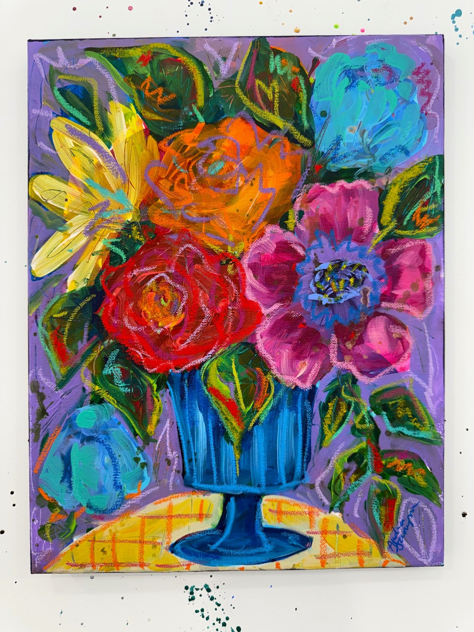Original painting of a colorful bouquet in a blue pedestal vase on a yellow plaid tablecloth, featuring red roses, orange blooms, pink poppies, and teal flowers against a periwinkle lavender background. 11x14 inches, acrylic and oil pastel on canvas.