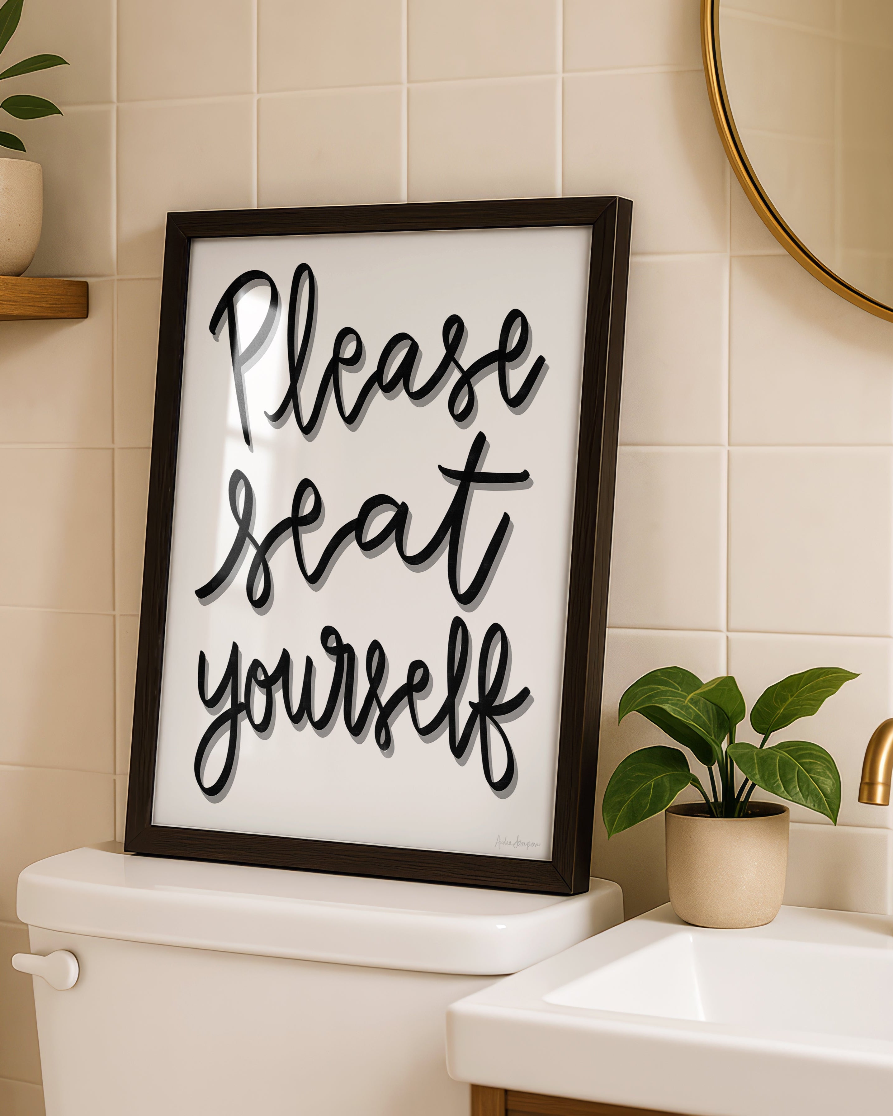Framed sign with 'Please seat yourself' text in a bathroom setting.
